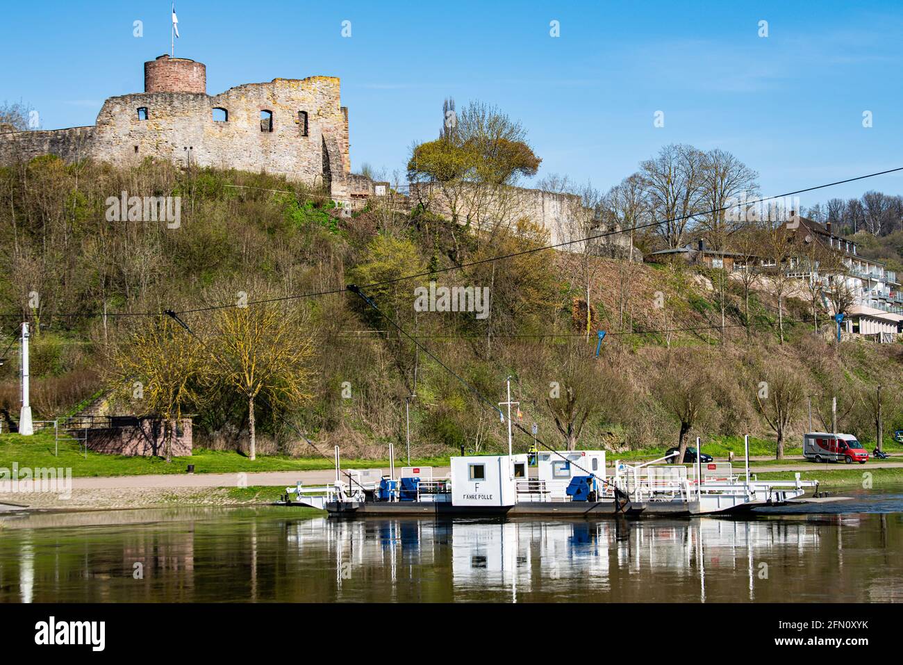 Polle, Germany. 21st Apr, 2021. The Polle yaw rope ferry, operated by the district of Holzminden, travels on the river Weser below the ruins of Polle Castle. The Weser ferry operates between the village of Polle and the district of Heidbrink. Credit: Swen Pförtner/dpa/Alamy Live News Stock Photo