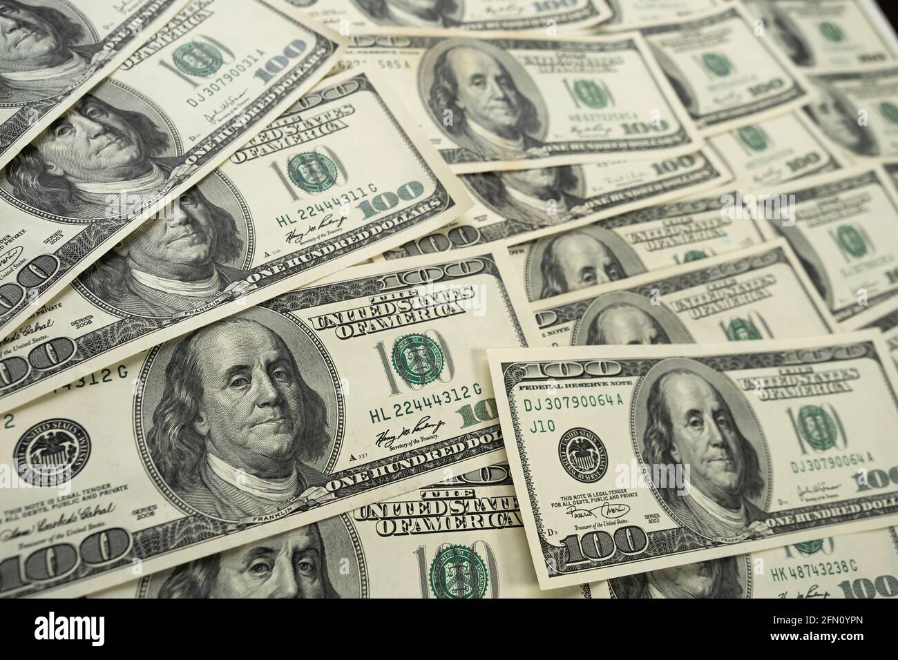 A money pile of one hundred US banknotes with president Franklin portrait. Cash of hundred dollar bills, paper currency background. Stock Photo