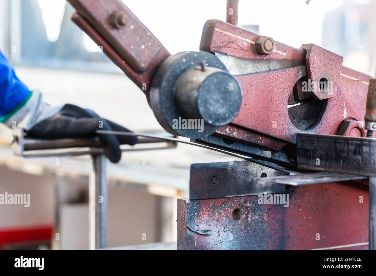 Craftsman cutting Metal with skip in workshop Stock Photo