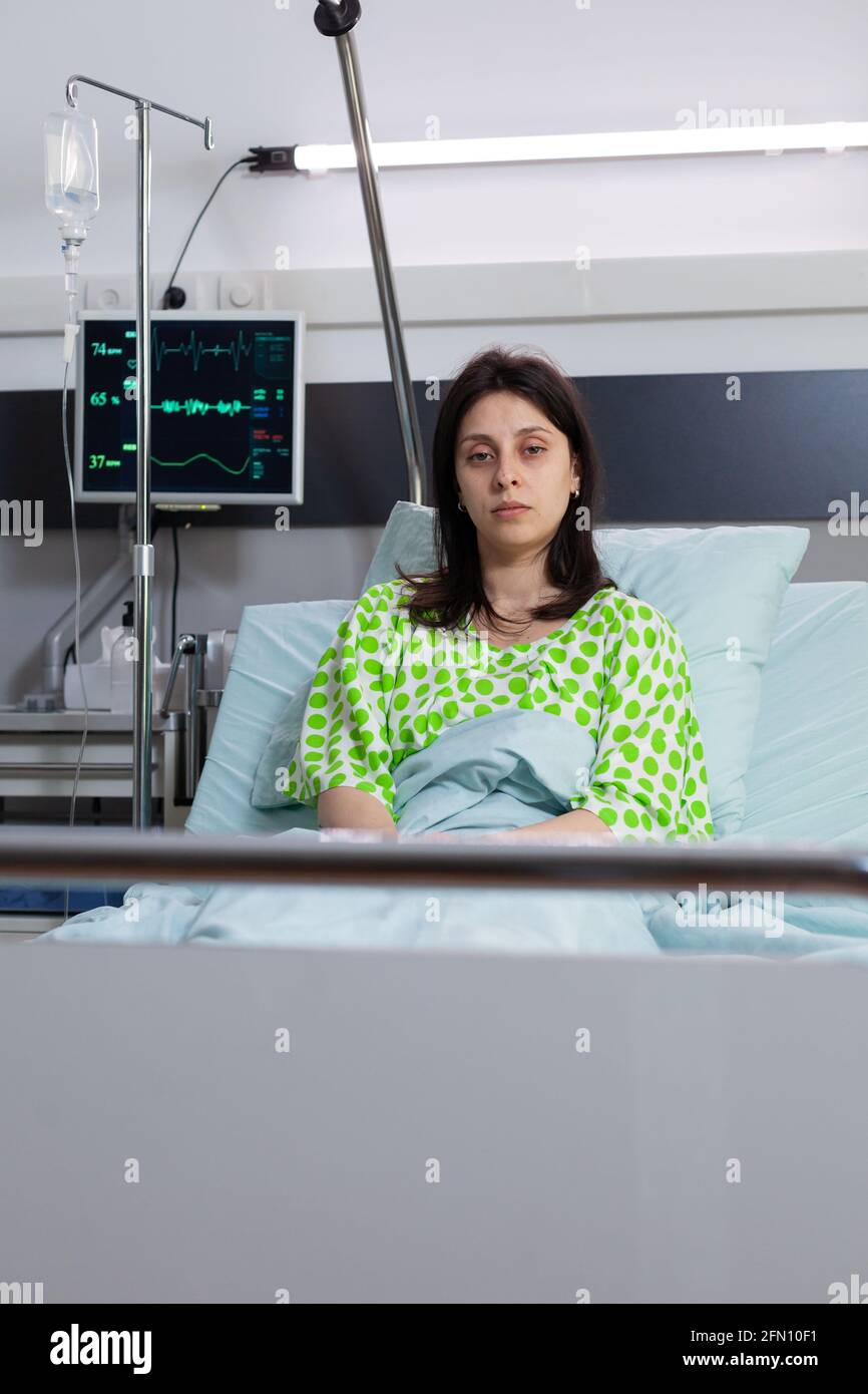 Hospitalized sick woman with nasal oxygen tube looking into camera