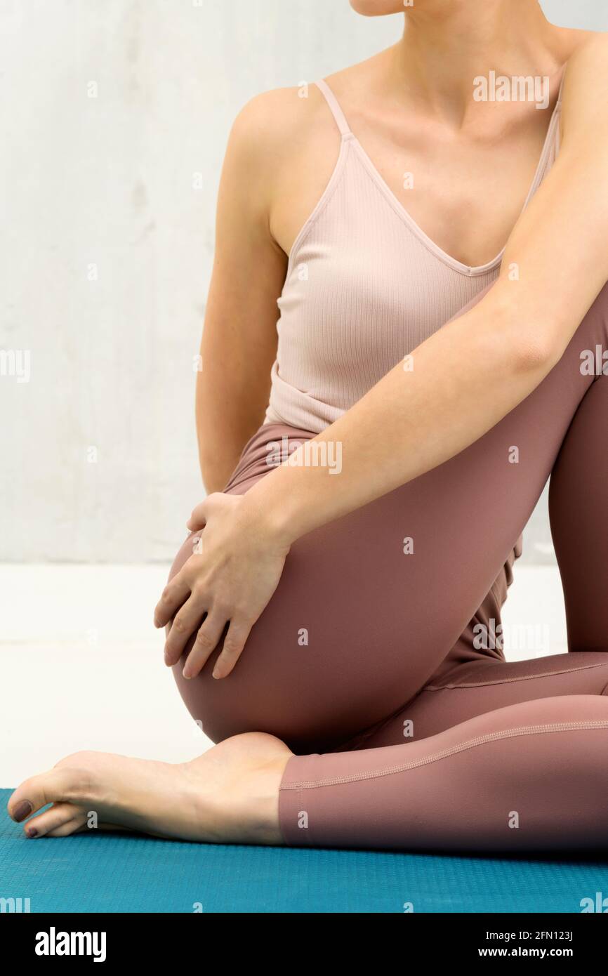 Close up cropped view of an anonymous woman in a Marichyasana Variation yoga pose twisting to grasp her thigh in a health and fitness concept Stock Photo