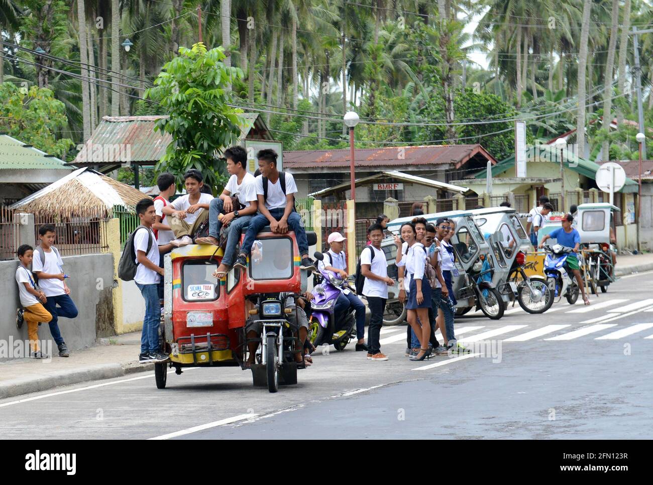 School students riding a tricycle in Sorsogon province in the Philippines. Stock Photo