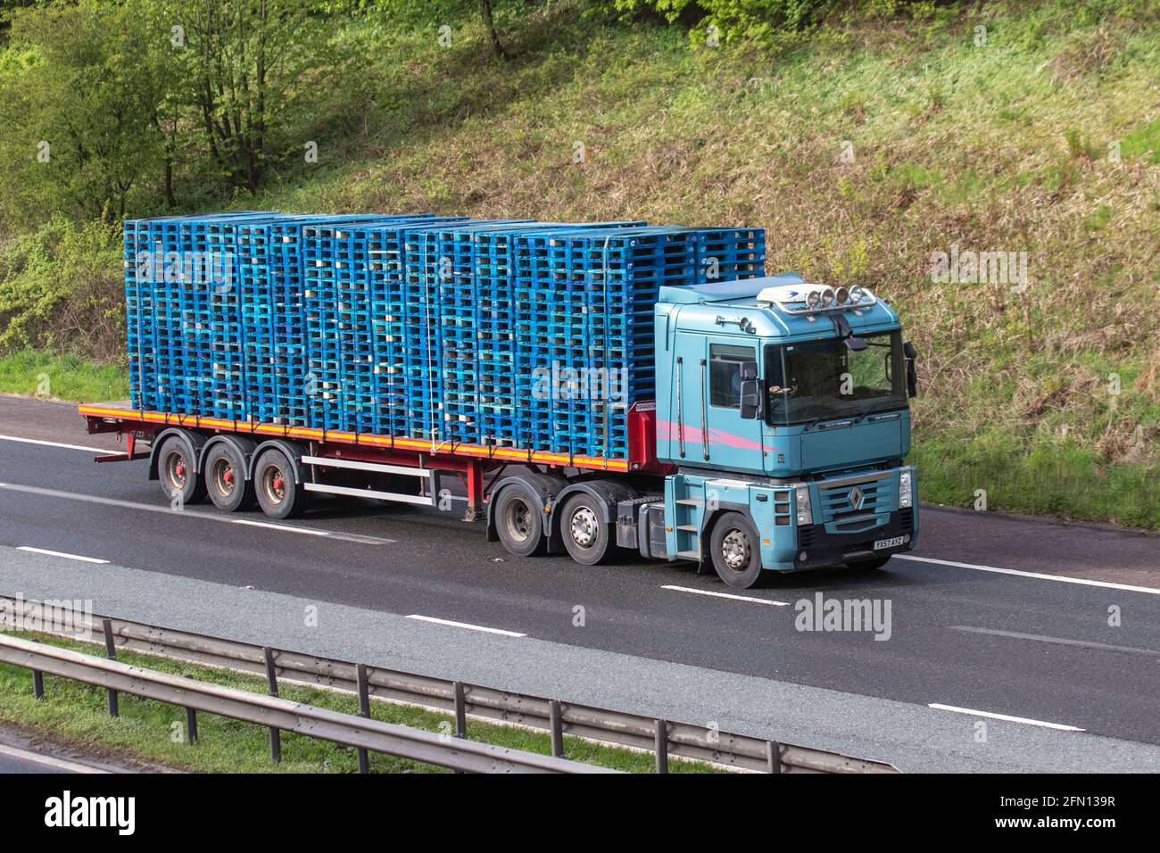 Stacked Wooden blue pallets on Renaulkt HGV vehicle; Heavy goods