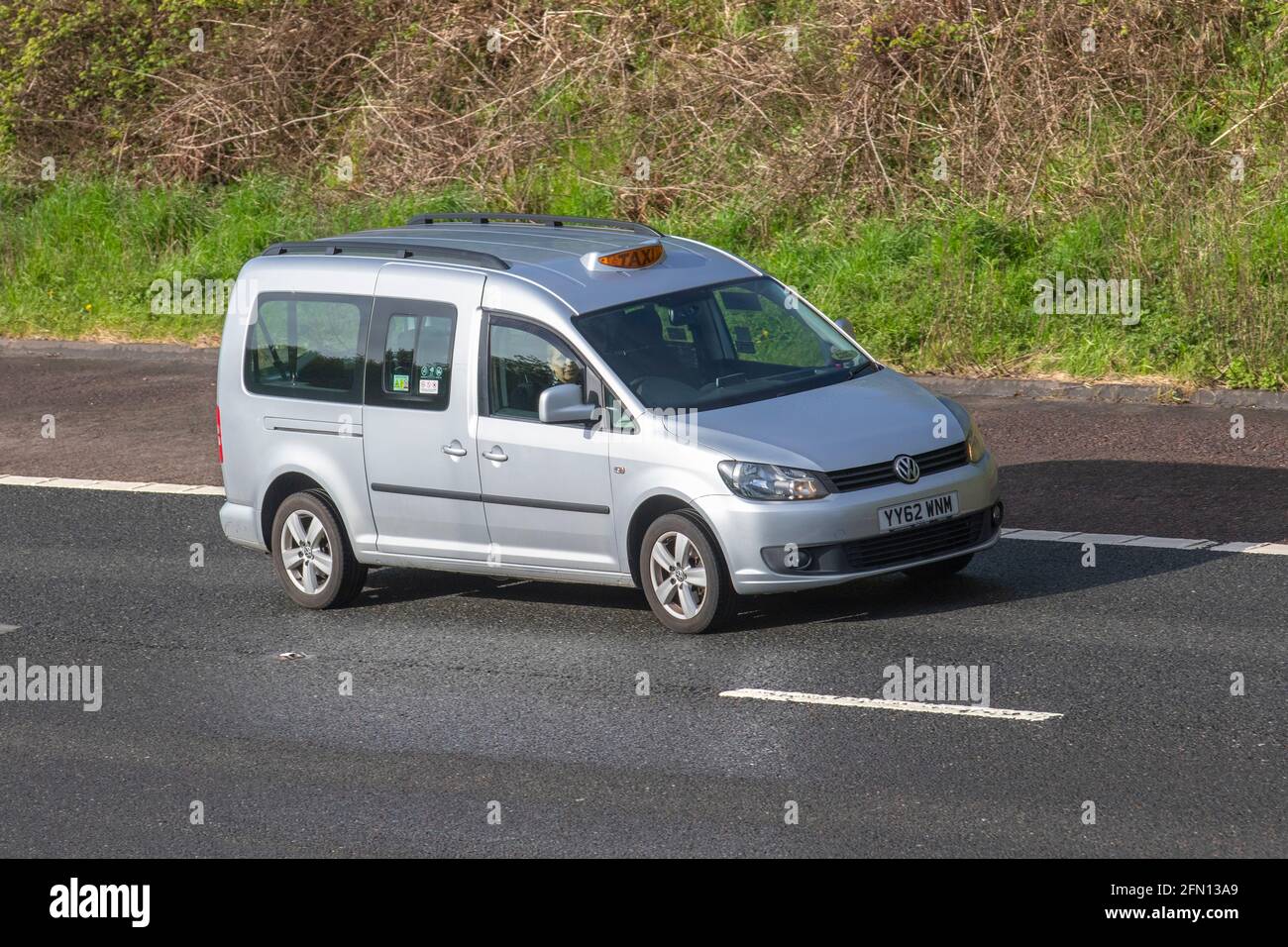 2013 silver VW Volkswagen Caddy Maxi C20 Life Tdi S-A;Vehicular traffic, moving vehicles, cars, Taxi vehicle driving on UK roads, motors, motoring on the M6 motorway highway UK road network. Stock Photo