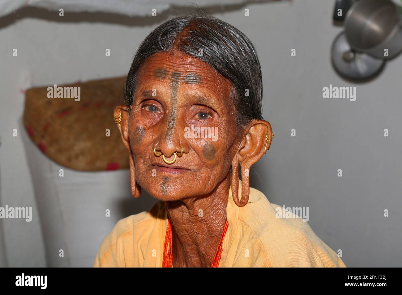 Tribal old woman with big ear lobes. Characteristic tattoo mark down the middle of the forehead is also seen. LANJIA SAORA TRIBE. Puttasingh Village , Stock Photo