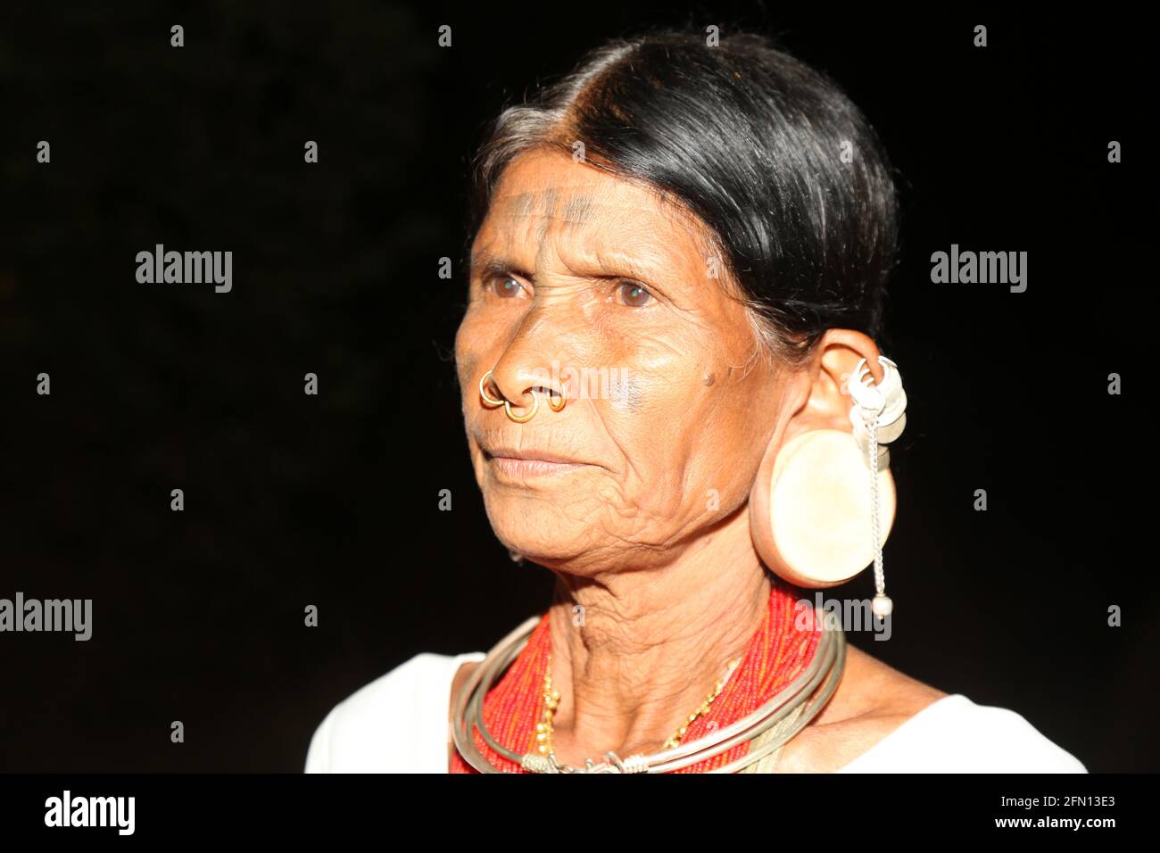 Closeup of  Tribal women with round wooden plugs in huge ear lobes. Characteristic tattoo mark down the middle of the forehead. LANJIA SAORA TRIBE. Pu Stock Photo