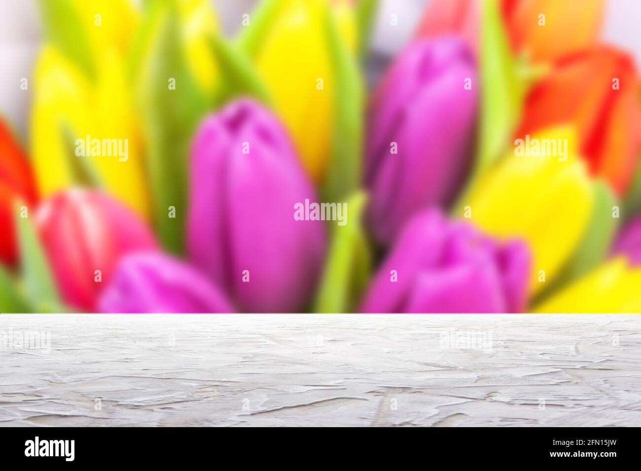 textured white surface on blur bouquet of colorful tulips background Stock Photo
