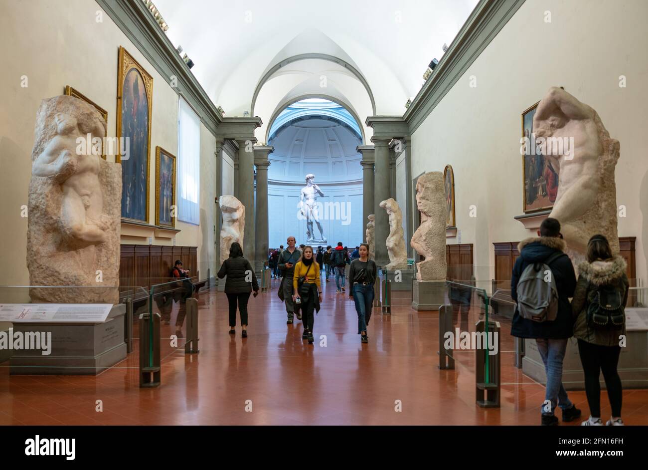 Florence, Italy, Accademia Gallery, sculptures unfinisced I Prigioni and sculpture of David in the background, by Michelangelo Stock Photo