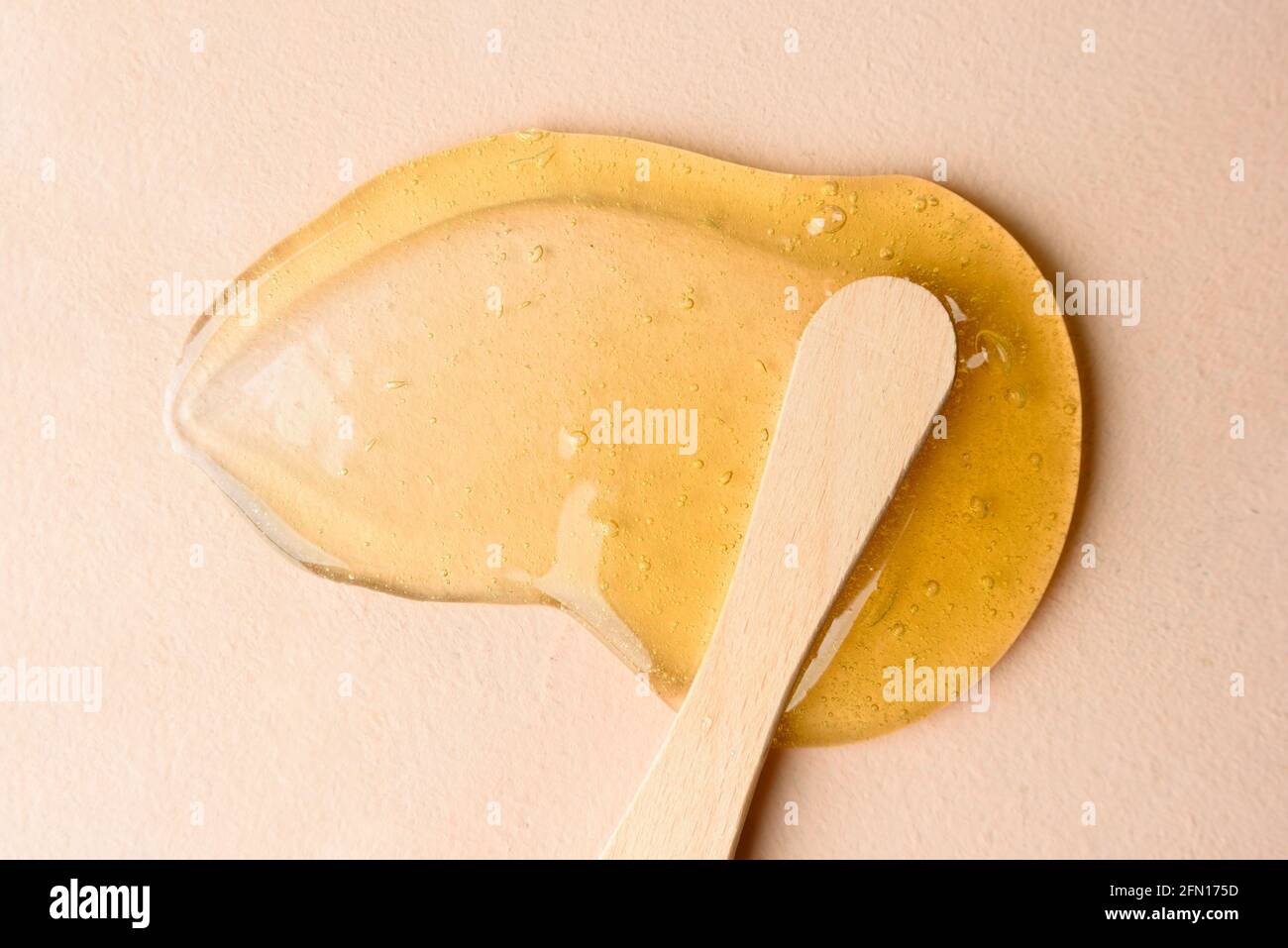 Liquid sugar wax smear with spatula on beige background Stock Photo Alamy
