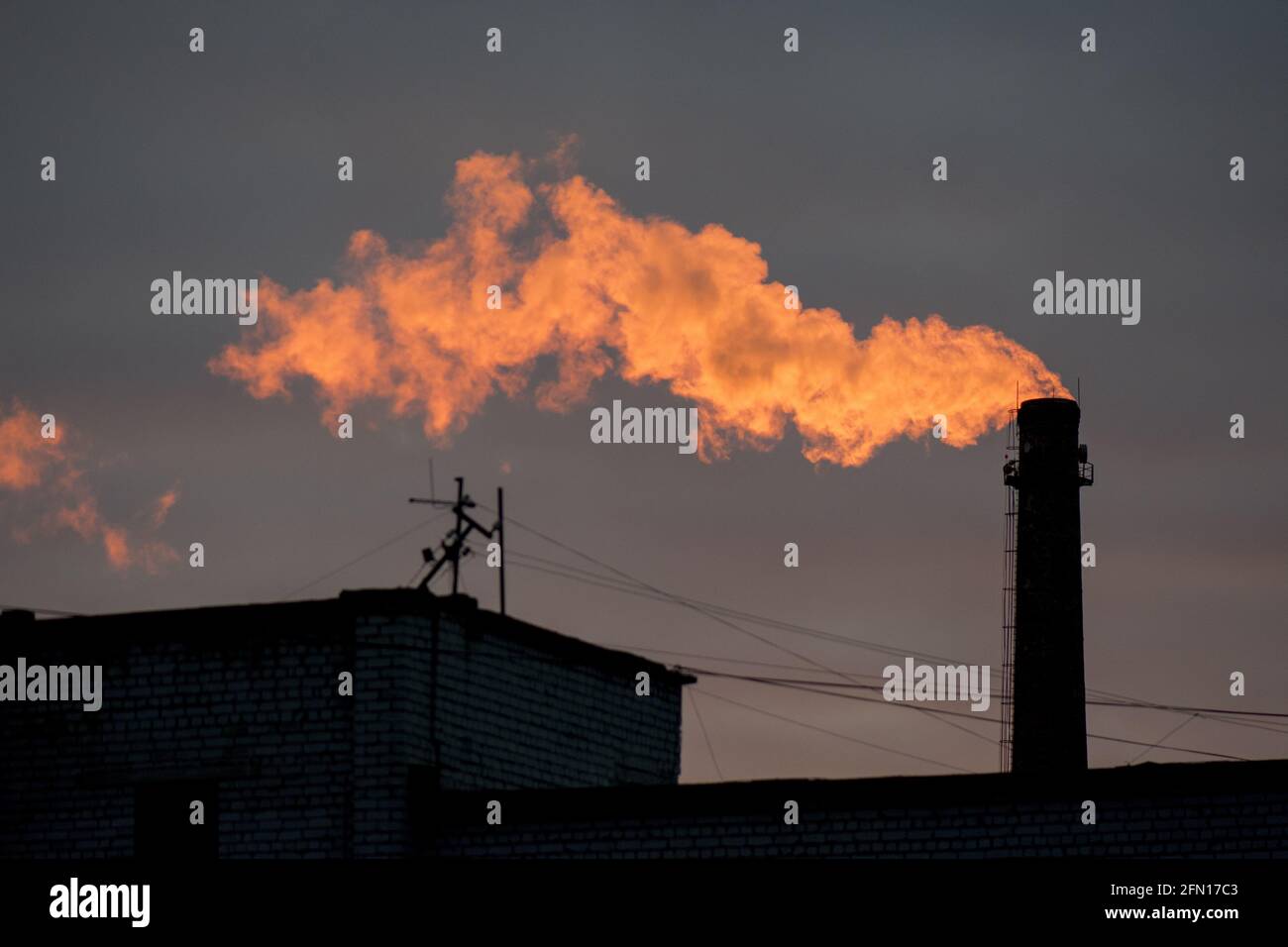 Flamecolor smoke coming out of the factory chimney Stock Photo Alamy