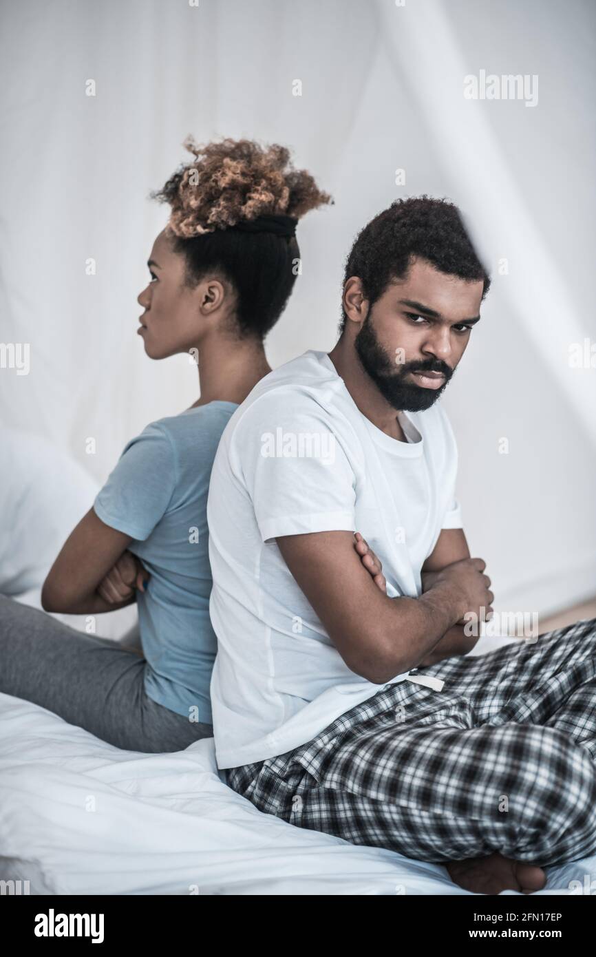 Man and woman sitting with backs to each other Stock Photo