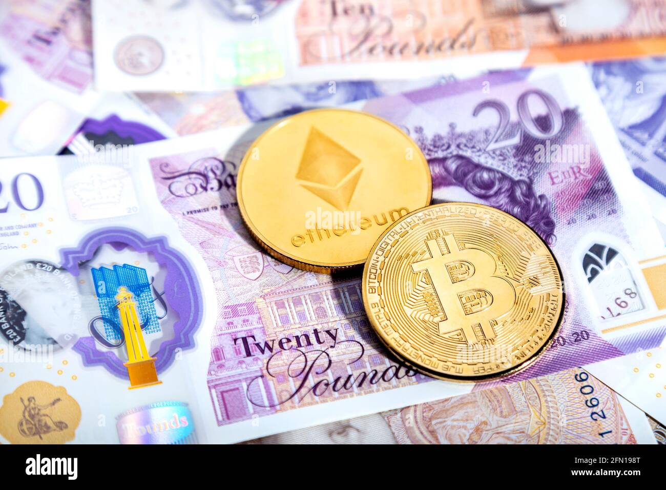 Cryptocurrency bitcoin and ether (ethereum) token coins against British Ponuds GBP Stock Photo