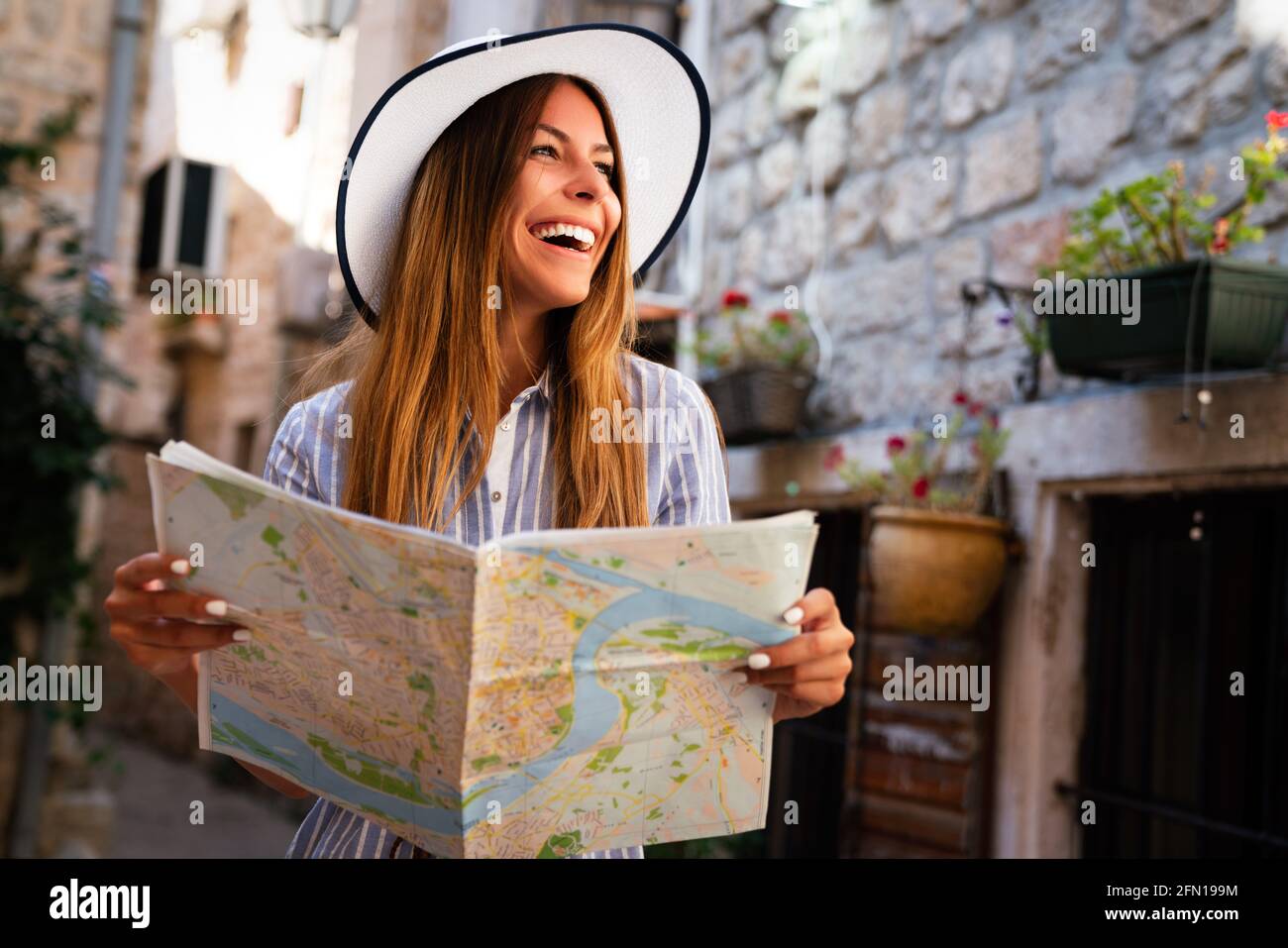Happy young woman with map in city. Travel tourist people fun concept. Stock Photo