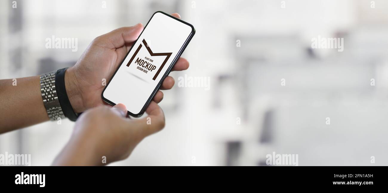 Close up view of male hands holding mock up smartphone on blurred ...