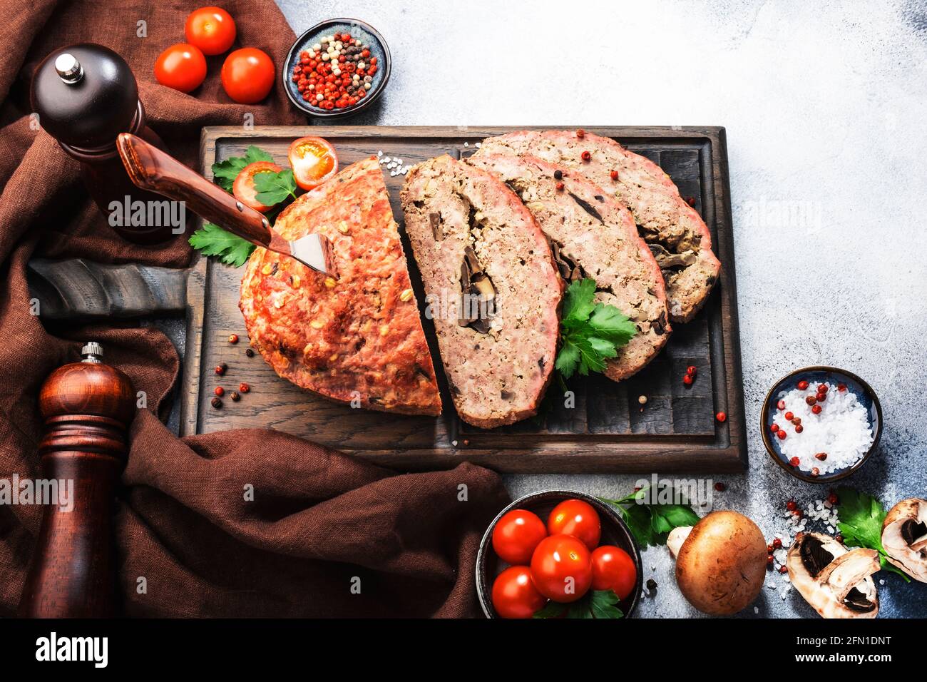 Meatloaf with mashrooms, classic american food with baked pork beef minced meat on cutting board. Top view Stock Photo