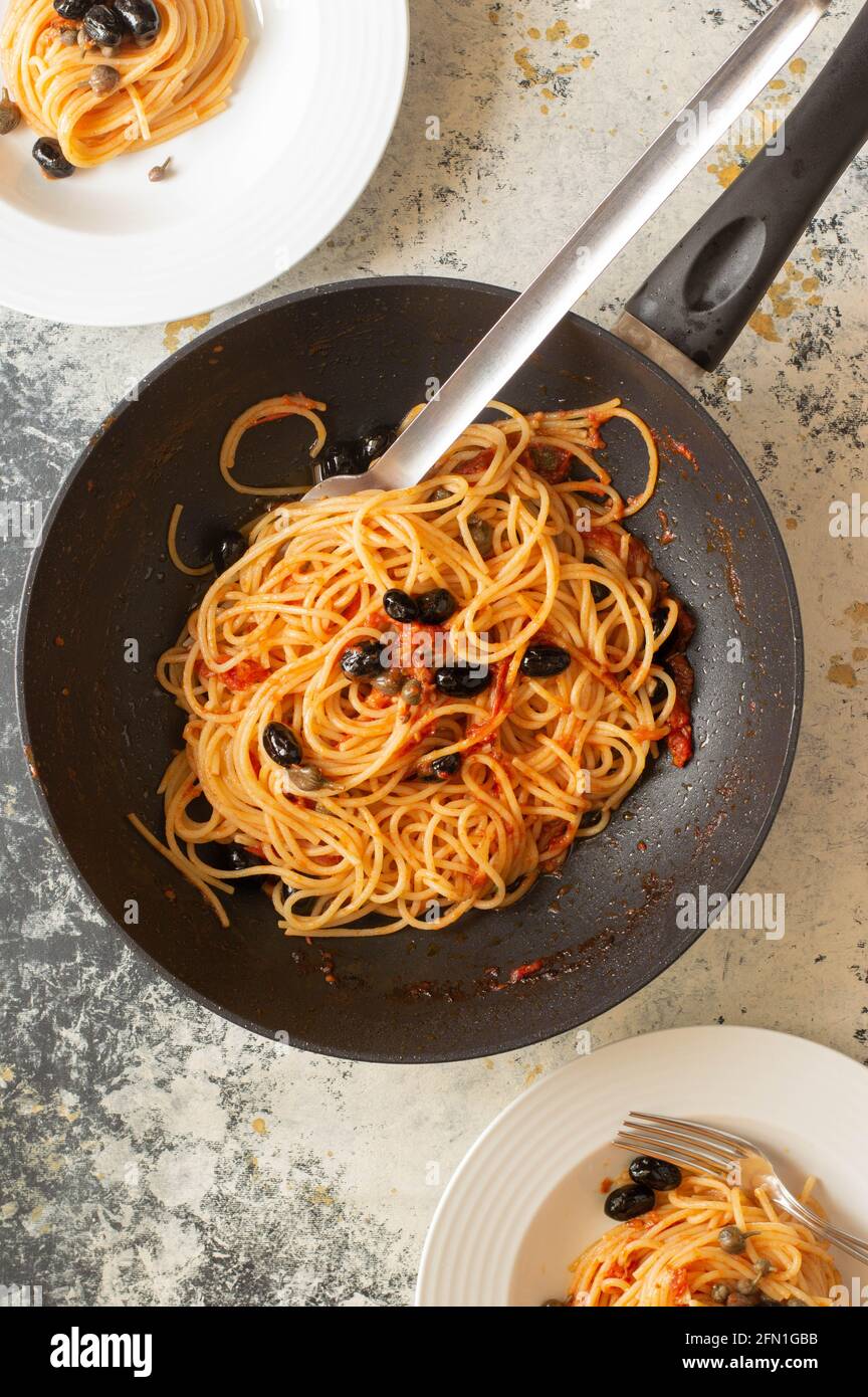 Puttanesca pasta: famous italian pasta with black olive and red tomatoes sauce Stock Photo