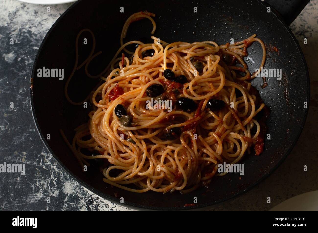 Puttanesca pasta: famous italian pasta with black olive and red tomatoes sauce Stock Photo