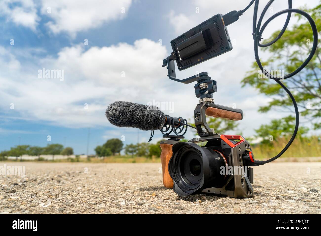 Full frame camera with external monitor, mic, and handheld film-making rig. Stock Photo