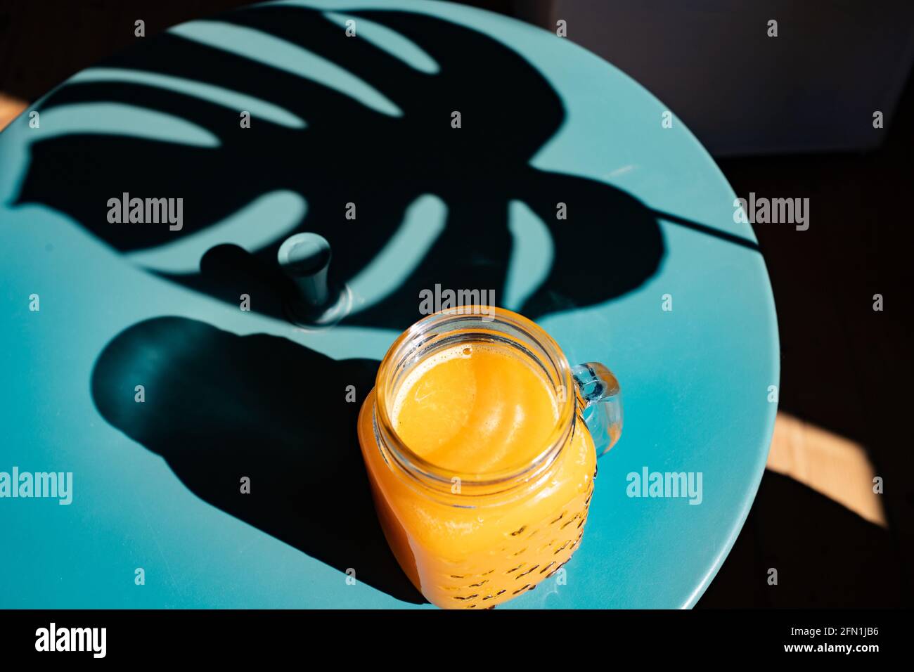 fresh orange juice in summer light and monstera or split-leaf philodendron  leaves Stock Photo - Alamy