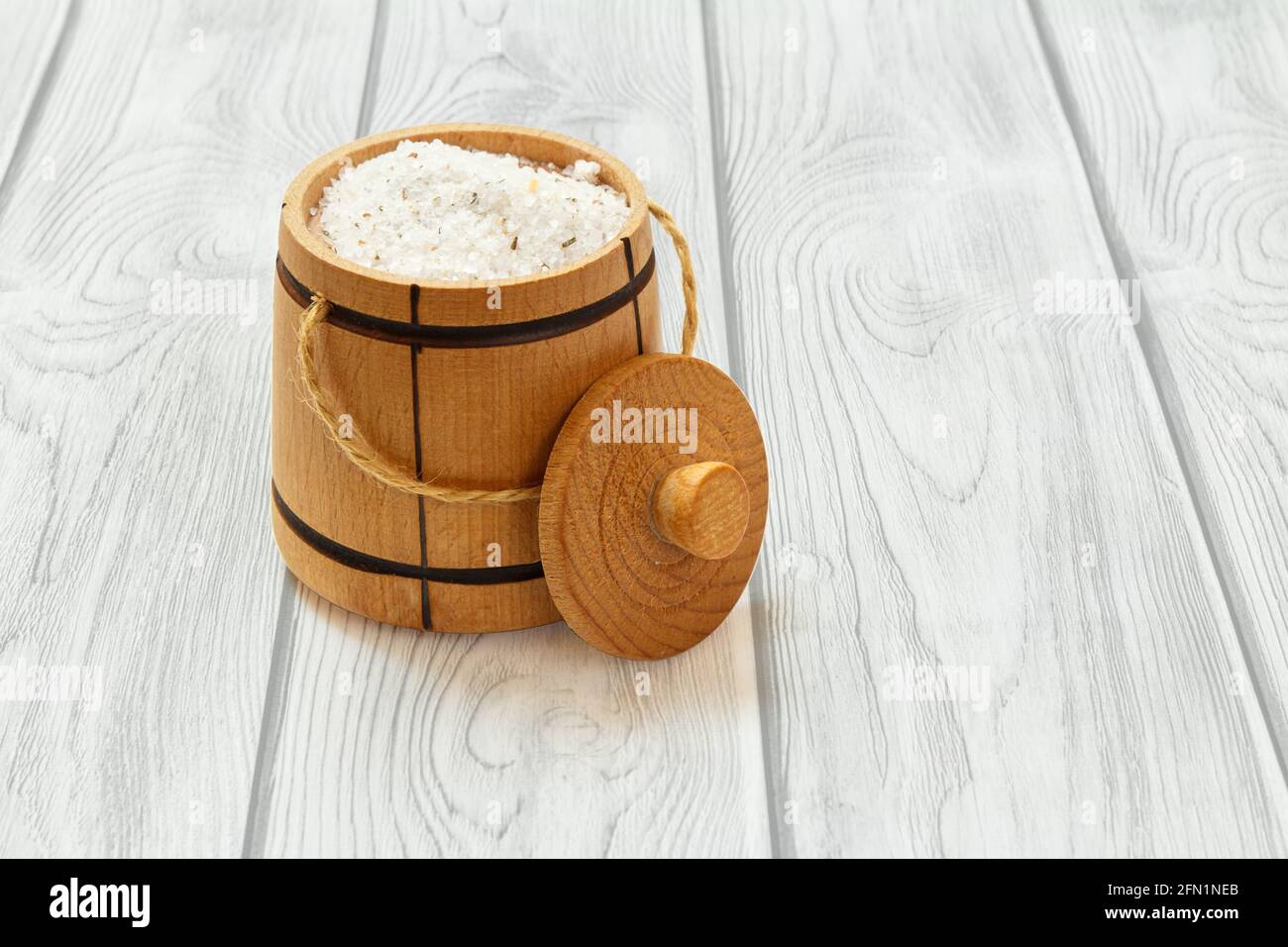 Container for storing salt. Wooden salt cellar on boards Stock Photo ...