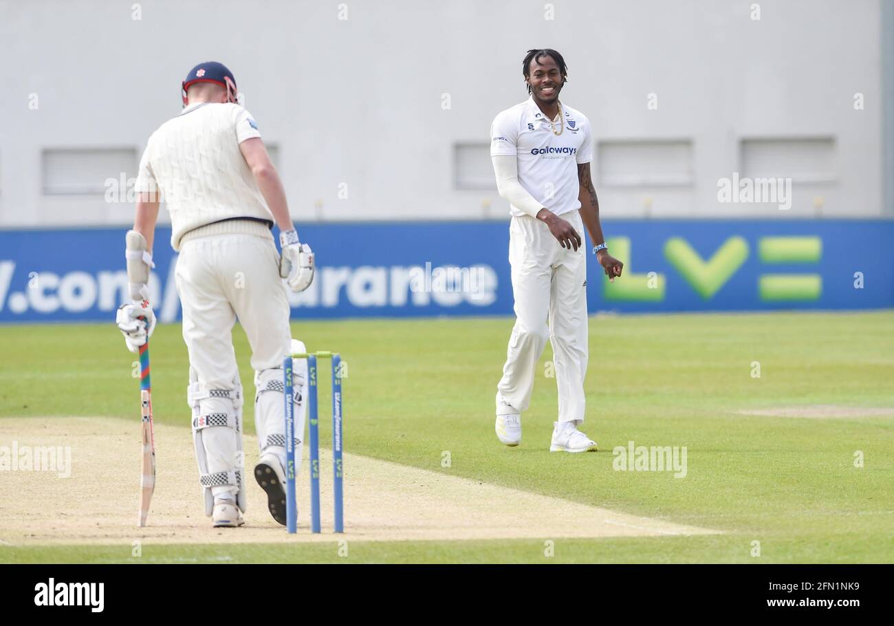 Hove, UK. 13th May, 2021. Sussex's Jofra Archer is all smiles as he bowls against Kent on the first day of their LV= Insurance County Championship match at The 1st Central County Ground in Hove . : Credit: Simon Dack/Alamy Live News Stock Photo