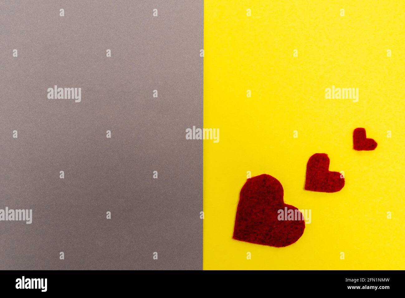 three red hearts. background gray yellow. the concept of Valentine's Day. Place for text Stock Photo