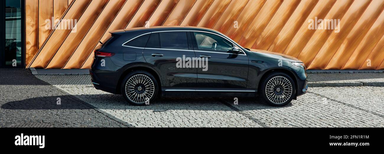 Electric Mercedes EQC standing against the golden wall of the Fire Museum. The car has a 408HP engine and accelerates 0-100 km-h in 5.1 seconds. Range Stock Photo