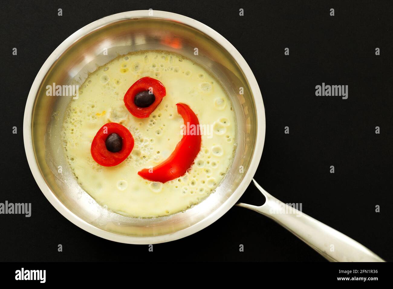 Funny face omelette with vegetables in frying pan, Copy space, Top view, Food Concept. Stock Photo