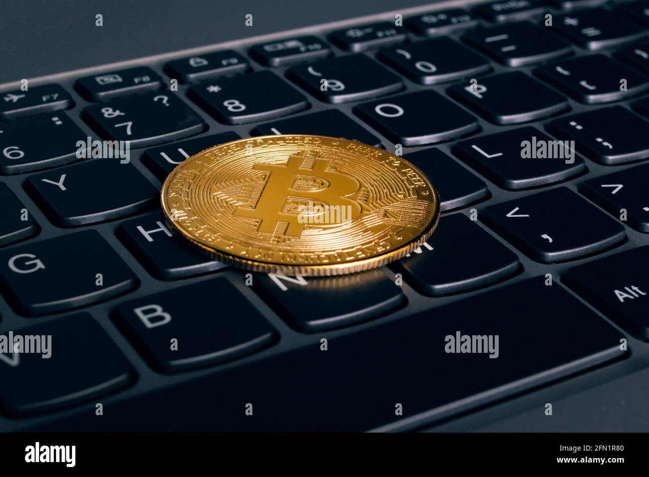 One bitcoins on a computer keyboard close up Stock Photo - Alamy