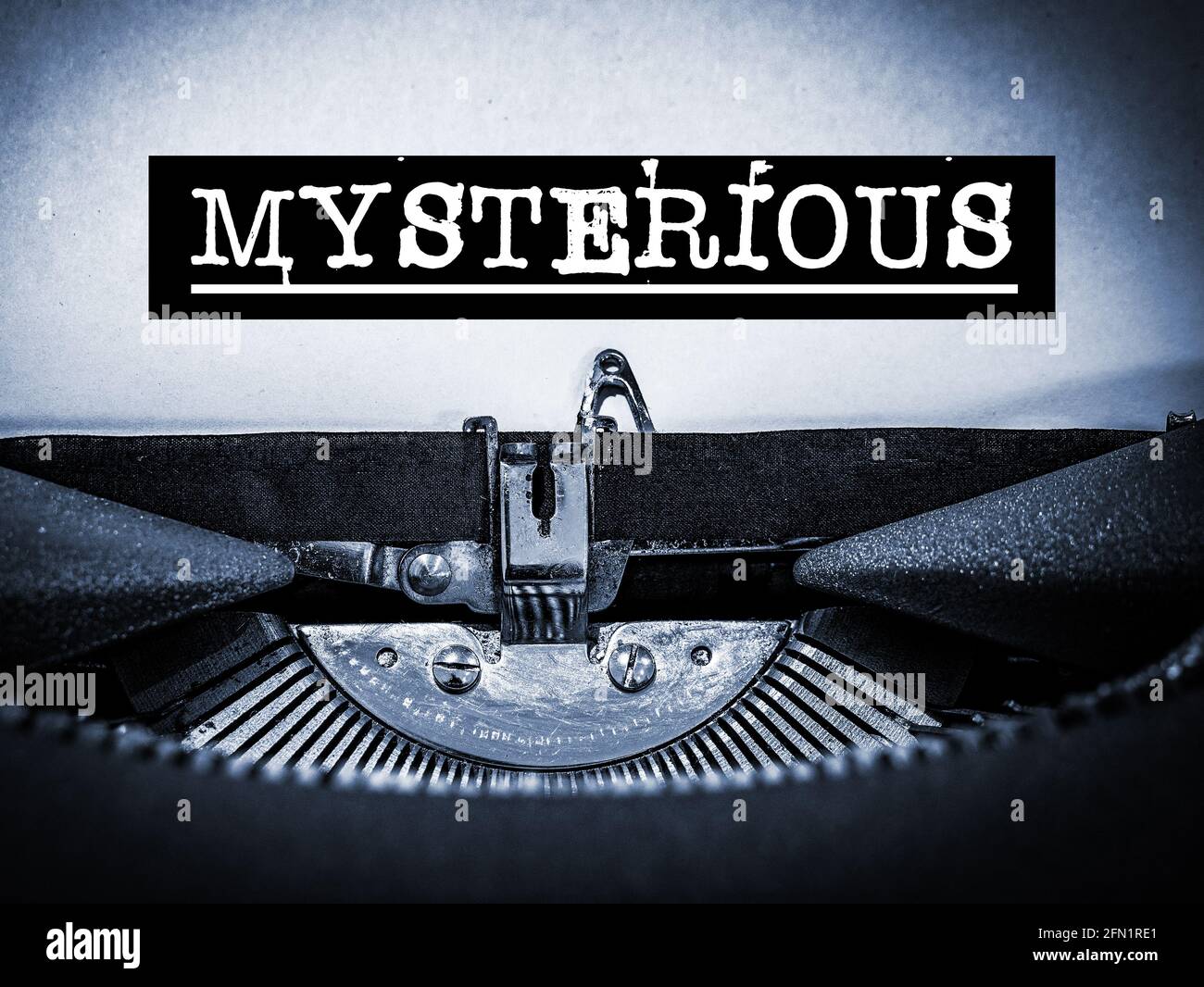 Mysterious displayed on a vintage typewriter with underline text and black border in a blue tone Stock Photo