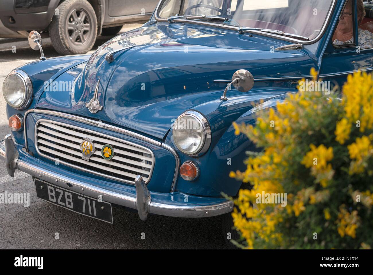 Blue Morris Minor 1000 parked on Henry Street in Kenmare, County Kerry, Ireland on a summer day in 2019. British tourists abroad. Stock Photo