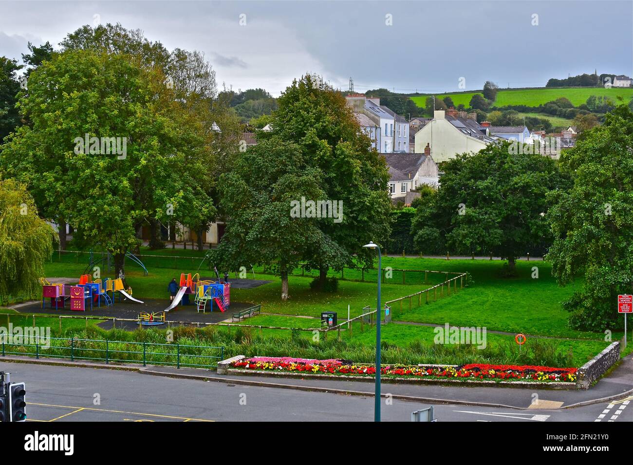 A pretty coloured play park to the rear of the main shopping area of Pembroke. Colourful flower beds in foreground. Stock Photo