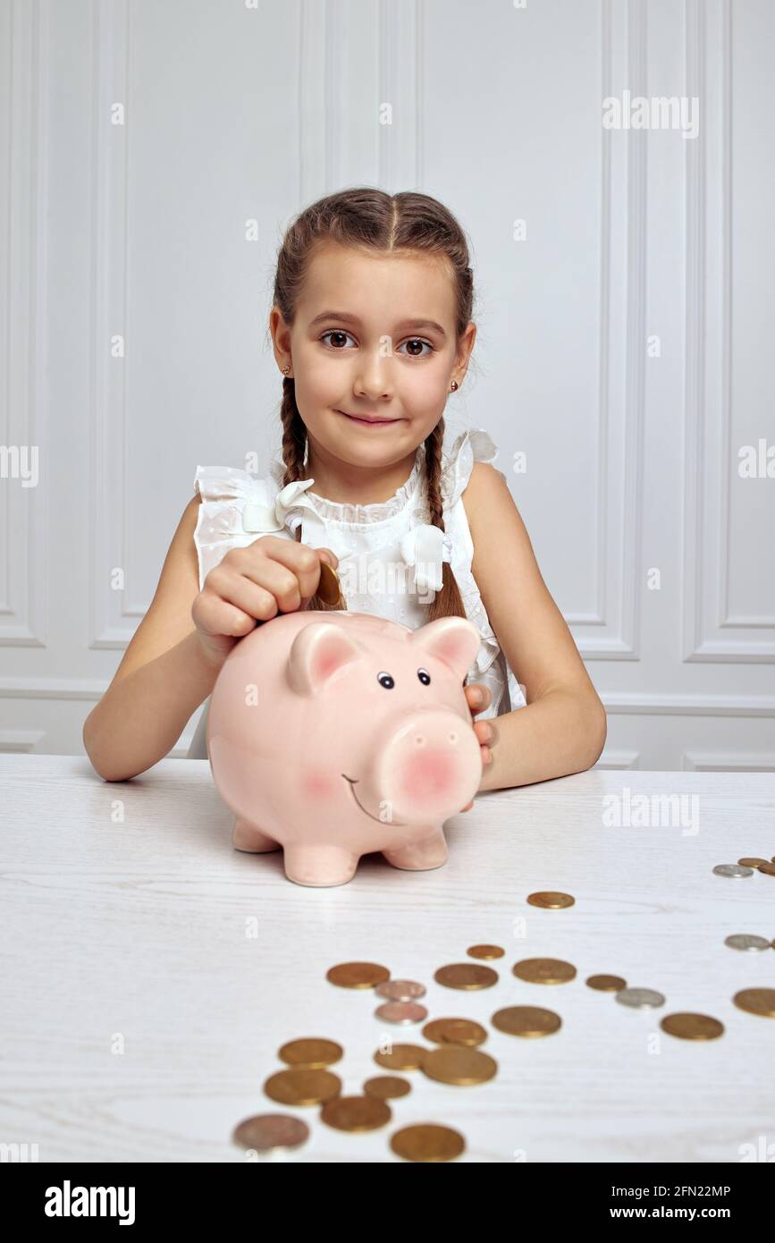 Little child girl with piggy bank at home Stock Photo Alamy