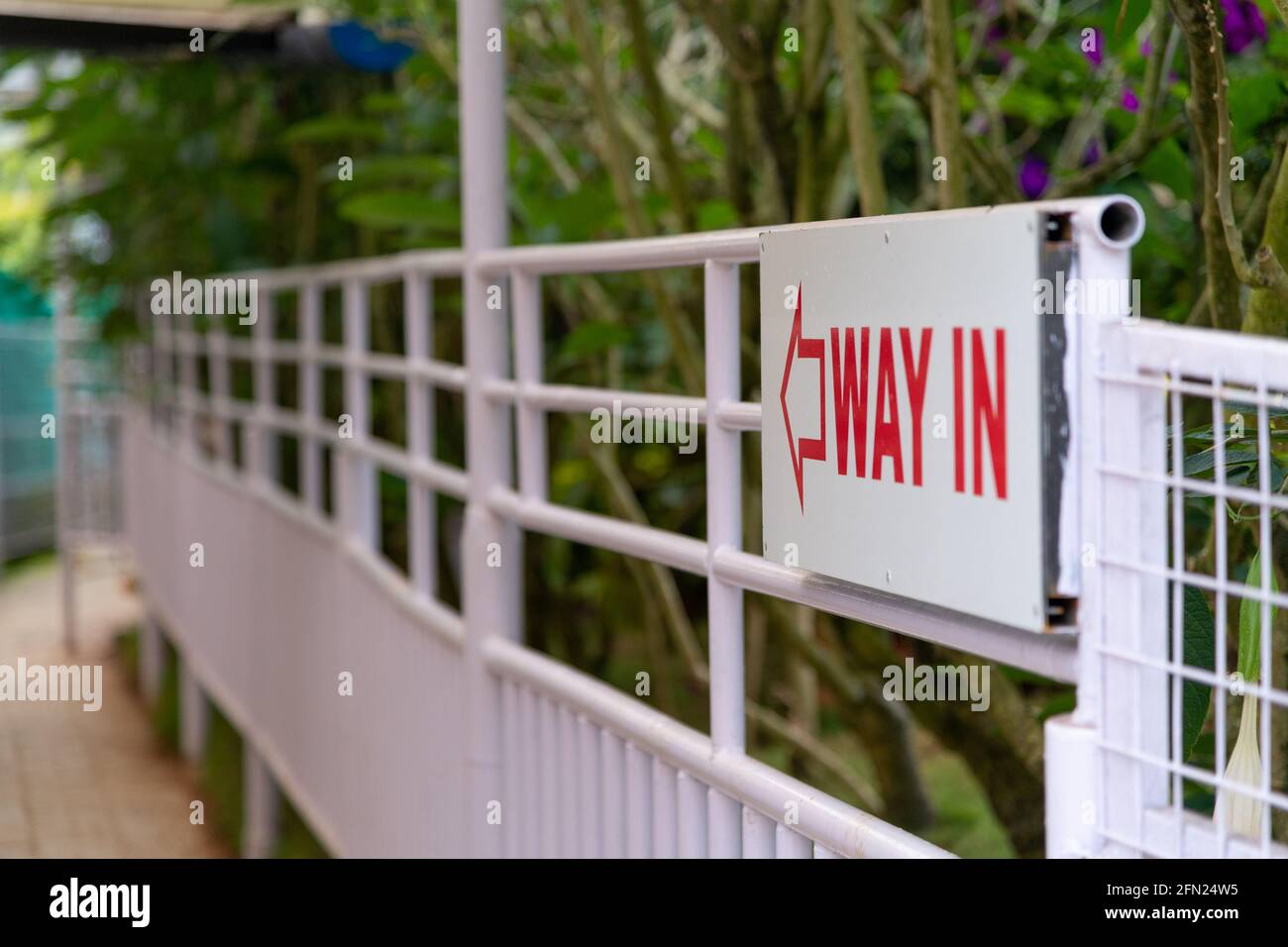 Way in sign board on railing at munnar botanical garden written in red in white background Stock Photo