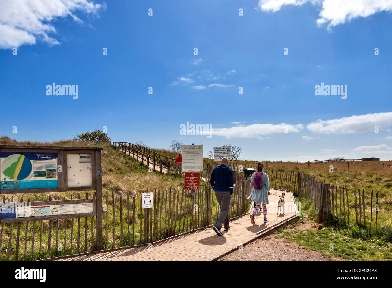 LUNAN BAY AND BEACH ANGUS SCOTLAND BOARDWALK AND SIGNS LEADING TO THE VIEWPOINT WITH PEOPLE AND DOGS Stock Photo