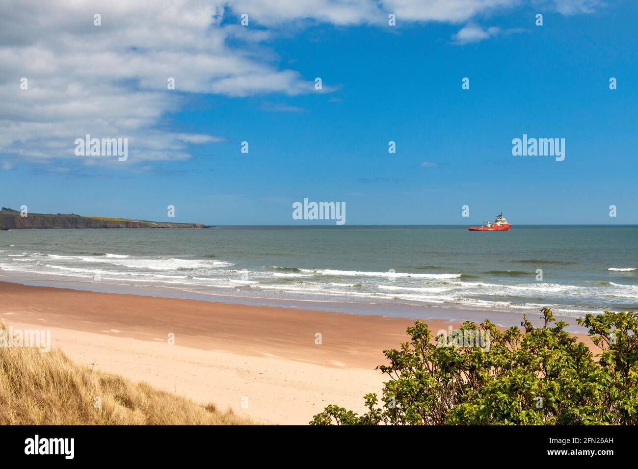 LUNAN BAY AND BEACH ANGUS SCOTLAND LOOKING SOUTH SANDY BEACH AND SEA WITH OIL RIG SUPPORT VESSEL Stock Photo