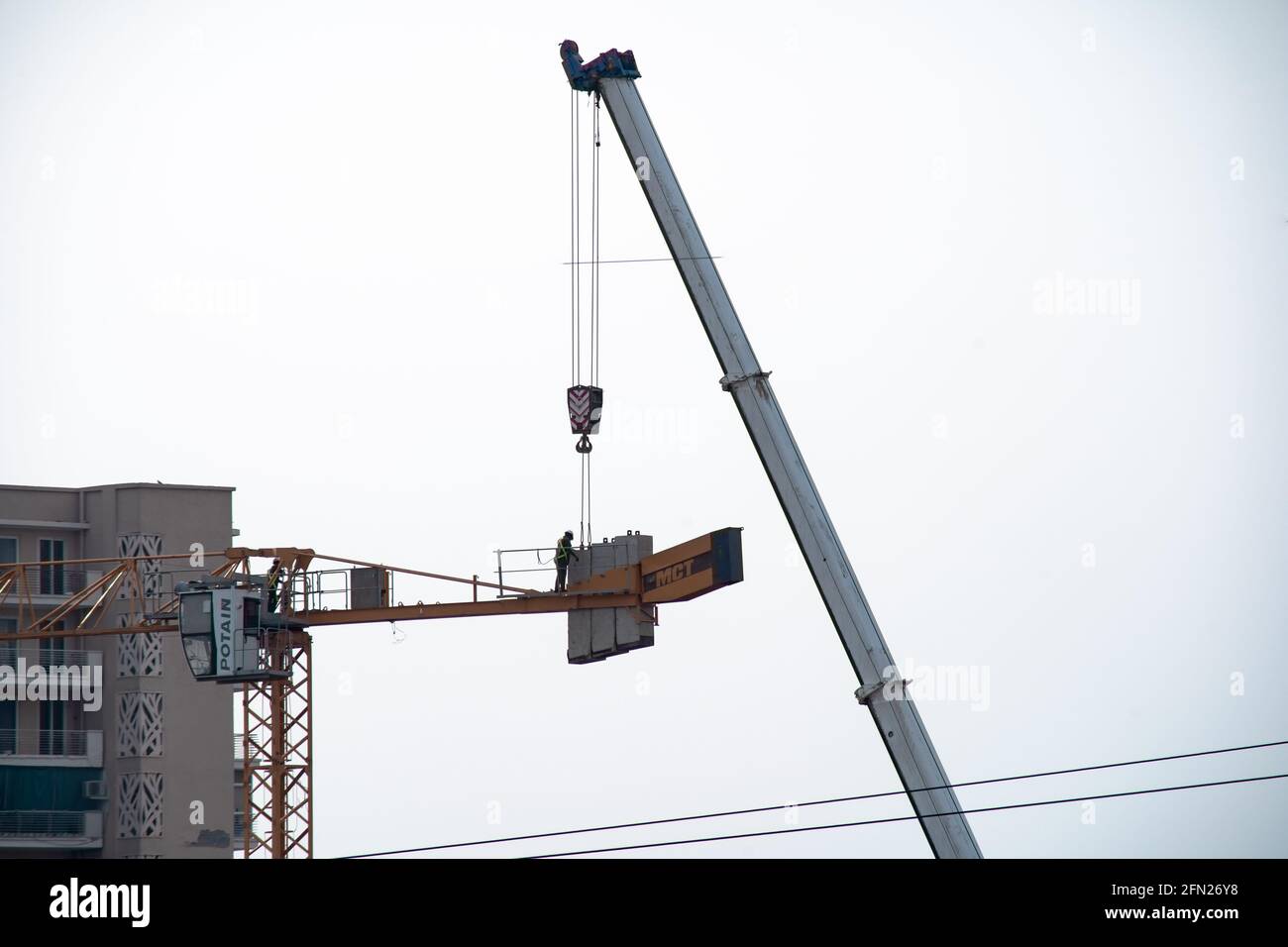 construction crane being built using a secondary crane shot against ...