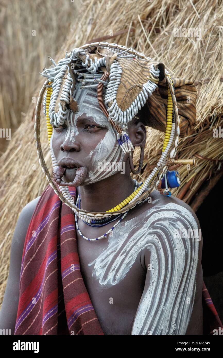 This Mursi woman has a stretched lip and dons a decorative headdress. OMO VALLEY, ETHIOPIA: MEET THE tribe where WOMEN are handed down to the next ava Stock Photo