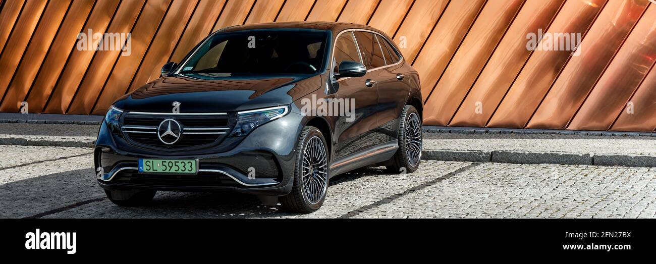 Electric Mercedes EQC standing against the golden wall of the Fire Museum. The car has a 408HP engine and accelerates 0-100 km / h in 5.1 seconds. Ran Stock Photo