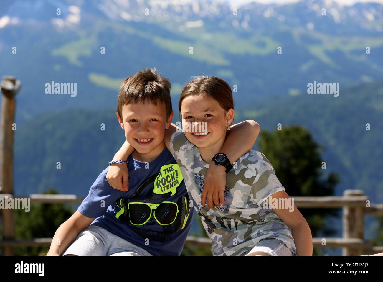 Kinder Mädchen und Junge umarmen sich auf einer Alm gegenüber des Langkofel Stock Photo
