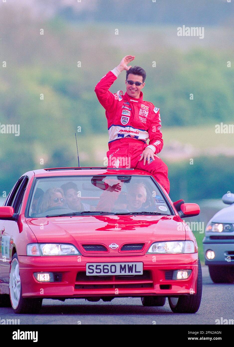 Matt Neal waving to the crowds Sat on top of a car on the parade lap of the British Touring Car Championship of 1999 at Thruxton Circuit England. Stock Photo