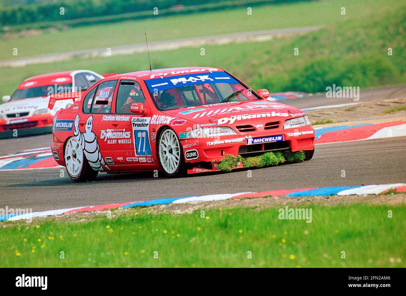 Matt Neal collecting grass in his front spoiler at Thruxton Circuit during the 1999 British Touring Car Championship driving his Max Power Racing Team Dynamics Nissan Primera GT. Stock Photo