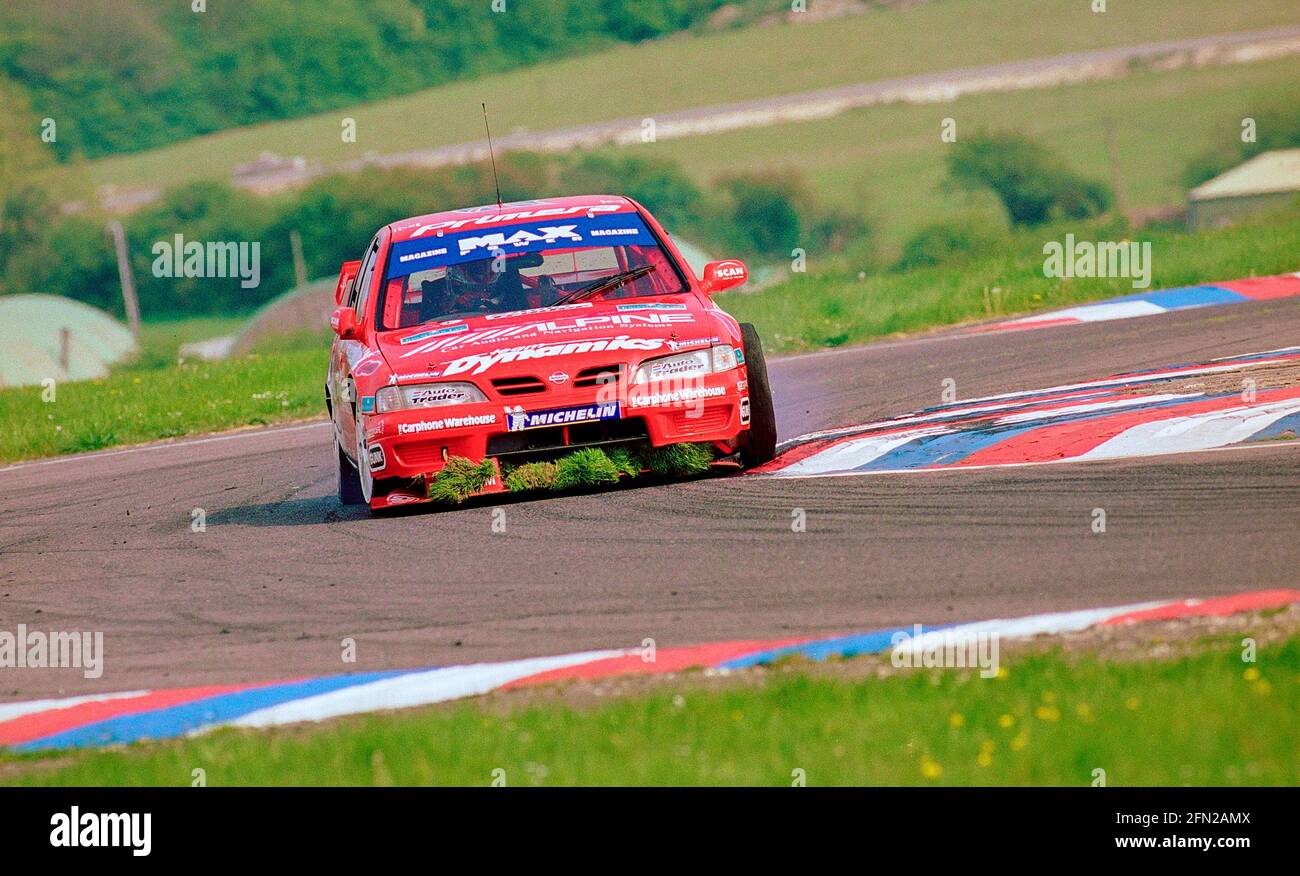 Matt Neal collecting grass in his front spoiler at Thruxton Circuit during the 1999 British Touring Car Championship driving his Max Power Racing Team Dynamics Nissan Primera GT. Stock Photo