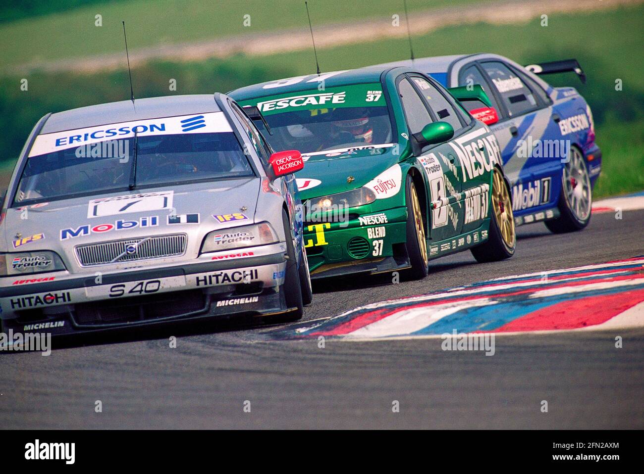 Jason Plato sandwiched in between the Volvo S40s of Rickard Rydell and Vincent Radermecker in his Renault Laguna as they exit Club Chicane in the British Touring Car Championship of 1999 at Thruxton circuit England. Stock Photo