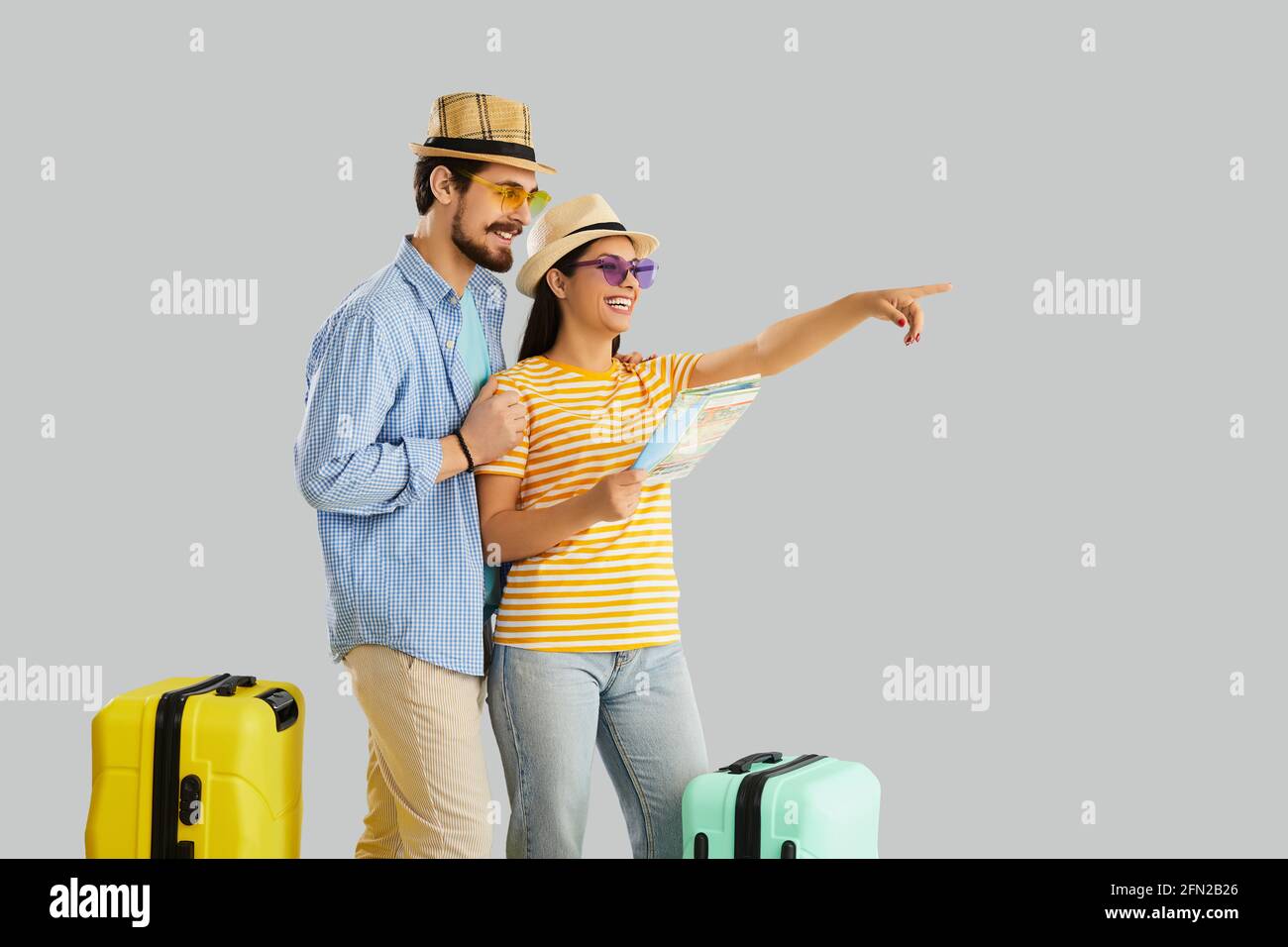 Happy couple traveler with map planning honeymoon vacation trip studio shot Stock Photo