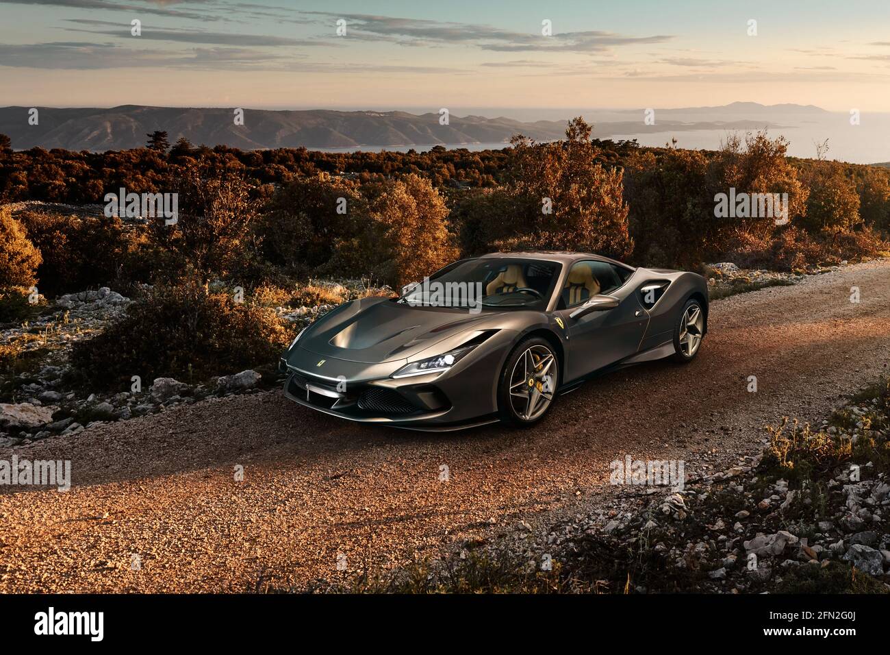 Katowice/Poland - 06.14.2019: Ferrari F8 Tributo on a gravel road on the island of Brac in Croatia. In the background there is a view of the Adriatic Stock Photo