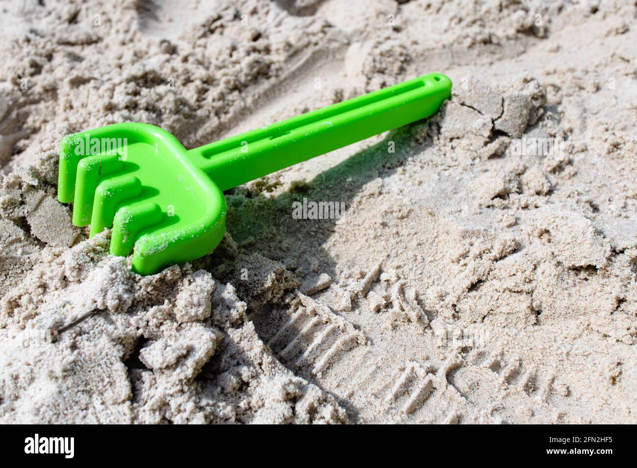 Toy rake for playing with sand on the beach on the sand Stock Photo - Alamy