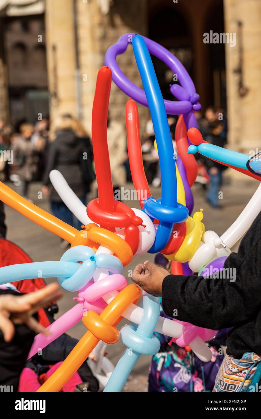 Balloon seller with multi colored balloons in the shape of a sword and  heart during the Carnival in Bologna city, Emilia Romagna, Italy, Europe  Stock Photo - Alamy