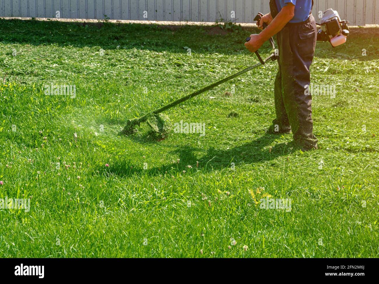 protective pants mows the green grass 