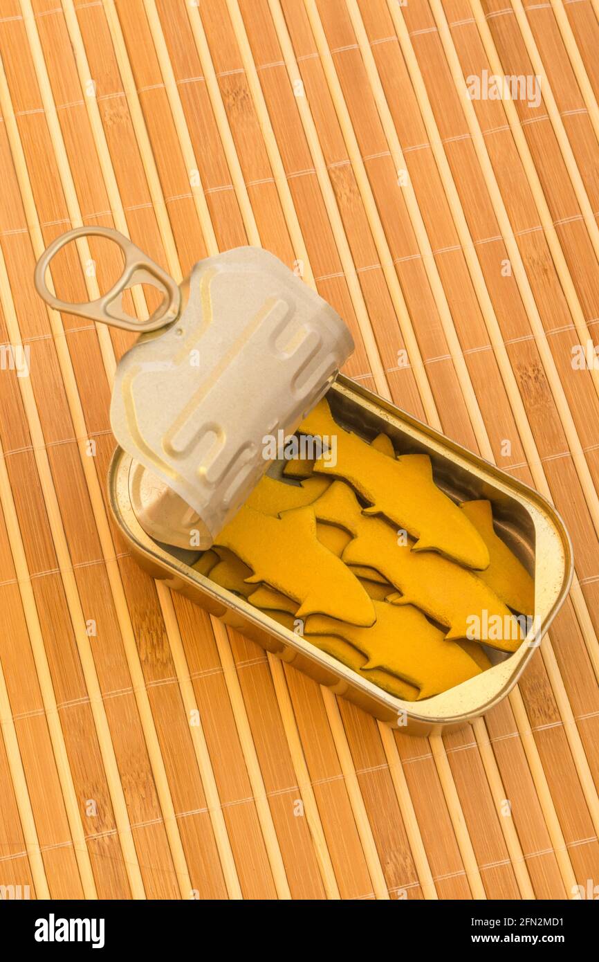 Tinned fish can with small wood figures of fish. For packed in like